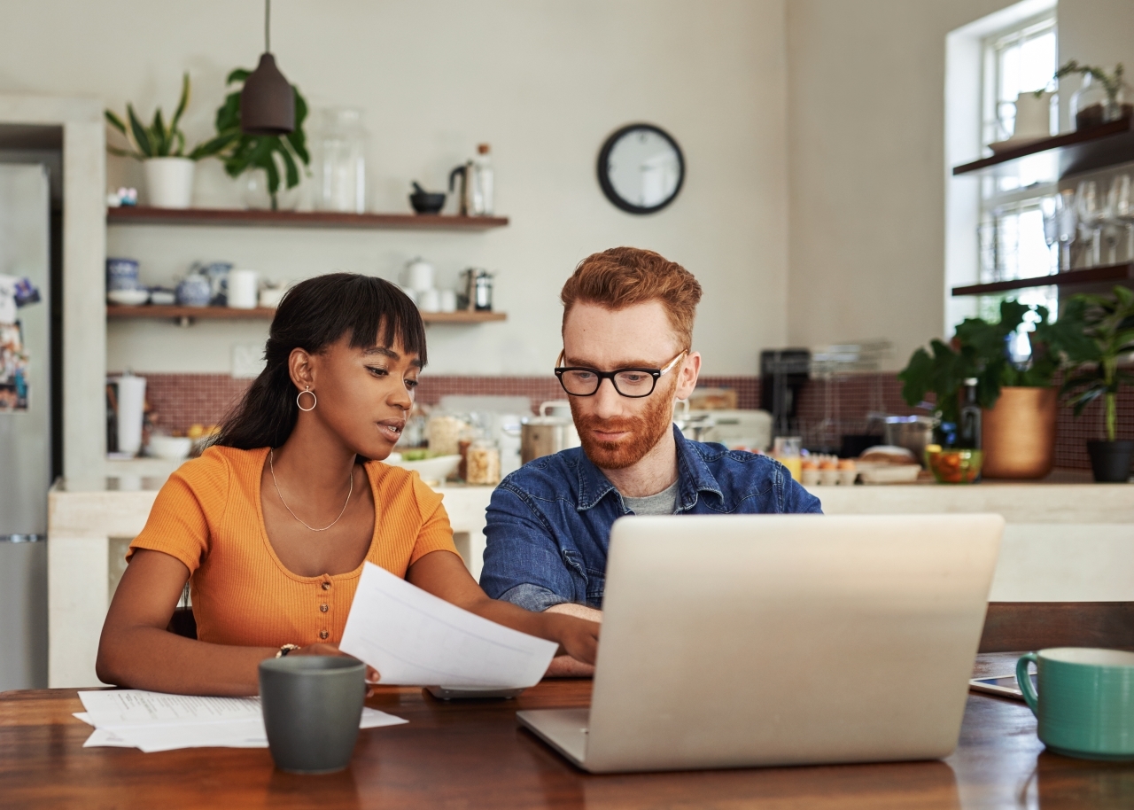 Couple looking at paperwork and computer